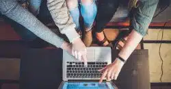 three person pointing the silver laptop computer