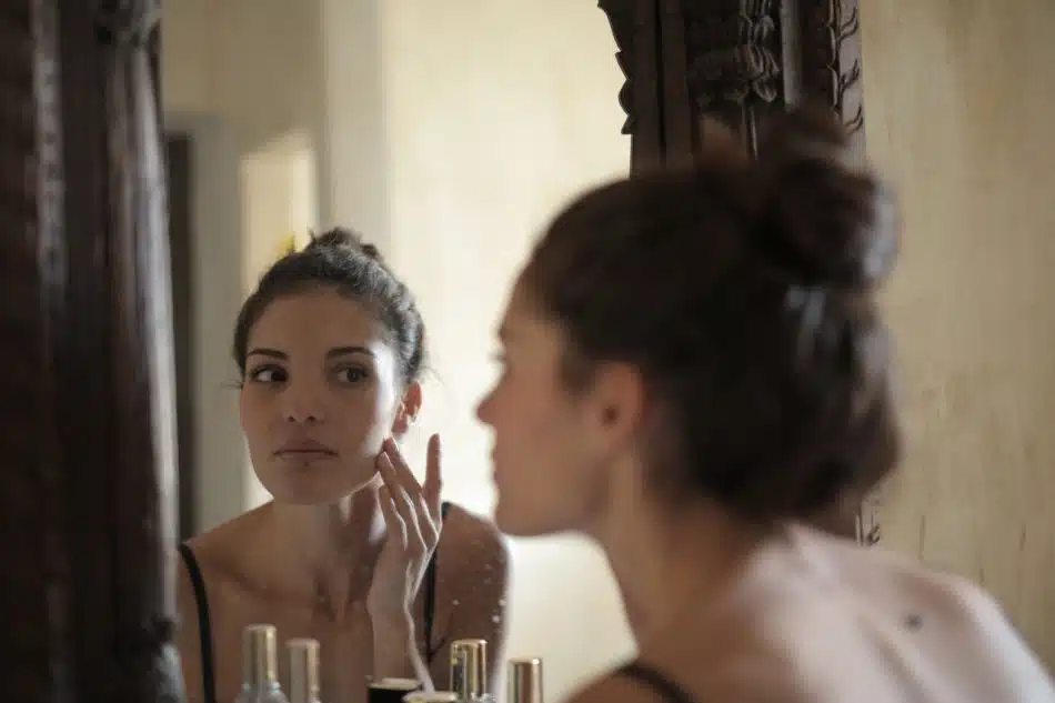 Une femme regardant son visage dans le miroir