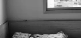 grayscale photo of person lying on bed