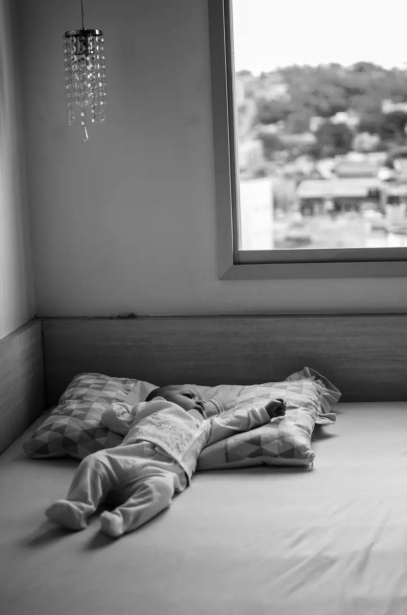 grayscale photo of person lying on bed